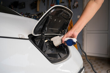 car electric charging port, female hand with charging, green ecological transport