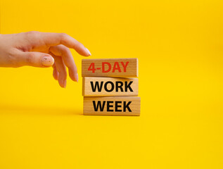 4-day work week symbol. Concept words 4-day work week on wooden blocks. Beautiful yellow background. Businessman hand. Business and 4-day work week concept. Copy space