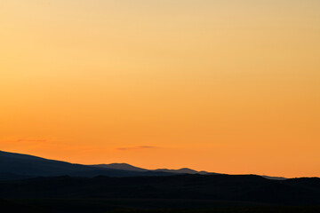 Obraz premium Bright orange sunset in the silhouette mountains. 