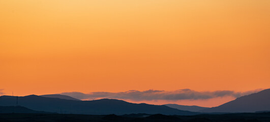 Bright orange sunset in the silhouette mountains.  