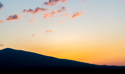Bright orange sunset in the silhouette mountains.  