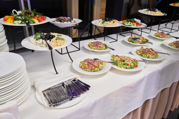 buffet with appetizers, salads in plates at the banquet