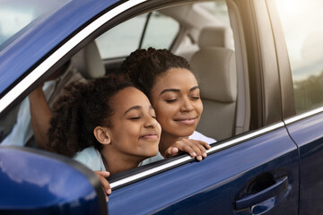 Joyful Black Mother And Daughter Sitting In Automobile Enjoying Trip