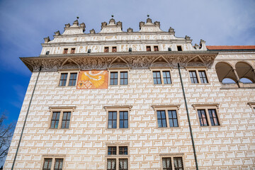 Litomysl, Czech Republic, 17 April 2022: Renaissance castle, UNESCO World Heritage Site, chateau with sgraffito mural decorated plaster at facade at sunny day, medieval historical town, sundial