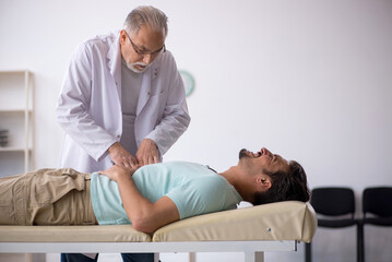 Obraz premium Young male patient visiting old male doctor