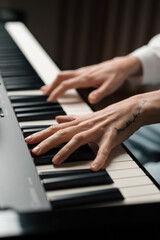 Obraz premium refined woman pianist plays the piano with thin fingers, sensually plays a musical instrument