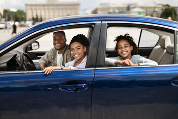 Happy Black Family Sitting In New Blue Car In City