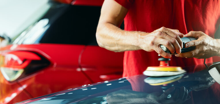 Car Detailing. Man Polishing Vehicle Body With Orbital Polish Machine And Wax. Copy Space