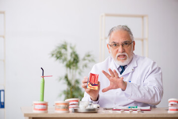 Old male doctor dentist working in the clinic