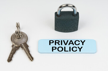 On a white surface there is a lock, keys and a blue sign with the inscription - Privacy policy