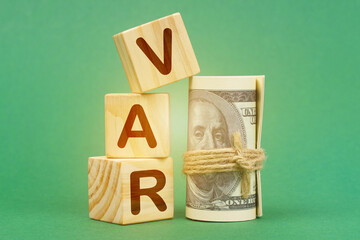 On a green surface, dollars and cubes with the inscription - VAR