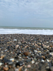 Pebbles on the seashore against the backdrop of waves. Close-up