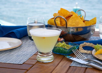 Hot Tin Tini cocktail and chips in a dinner table setting with a blurred background