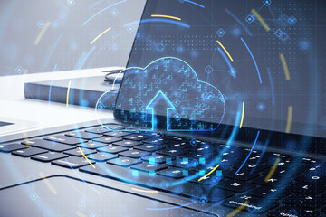 Cloud computing technology and data storage concept with digital graphic glowing blue cloud symbol with arrow up on laptop background, double exposure