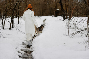 portrait of a woman outdoors in a field in winter walking with a dog fresh air
