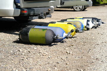 many gas cylinders for scuba diving, diving lie on the sand, on the seashore of the lake, concept...