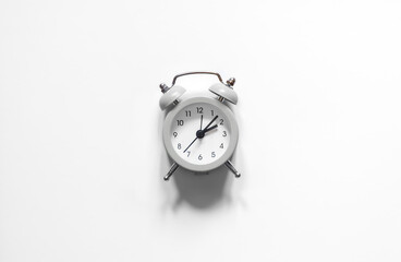 Alarm clock on a white background isolated, flat lay, black and white photo.