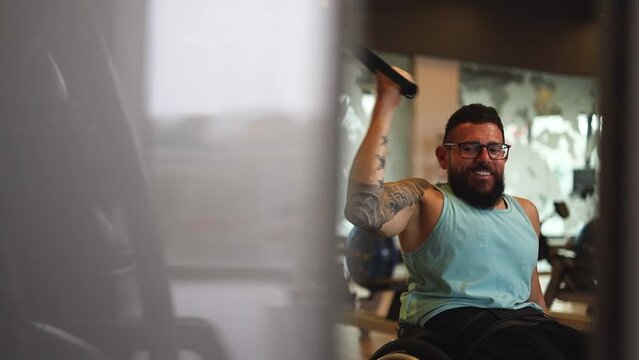 An athletic man on a chair training inside a gym.