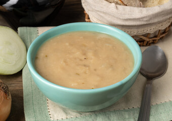 Onion soup in a bowl with bread and wine