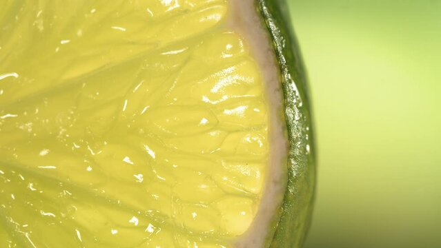 Drop of water flows down the surface of a ripe juicy Lime slice. Slow Motion 4K