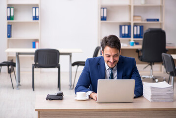 Young male employee and too much work in the office