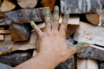 Dirty hand in front of firewood