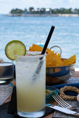 Agave margarita cocktail with chips and salsa in a dinner sitting on a tropical island. 