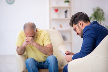 Fototapeta premium Old man visiting young male psychotherapist