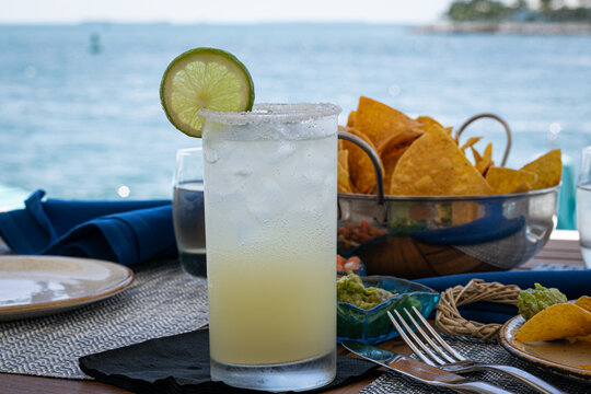 Agave margarita cocktail with chips and salsa in a dinner sitting on a tropical island. 