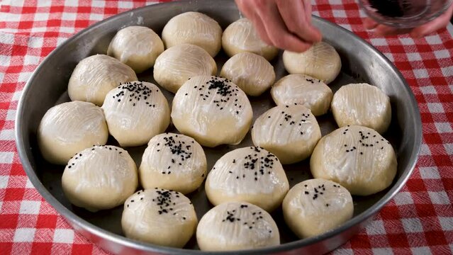 sprinkling black sesame on bread