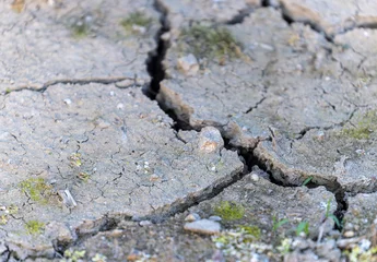 Muurstickers Large cracks form in arid ground amid drought © Osaze