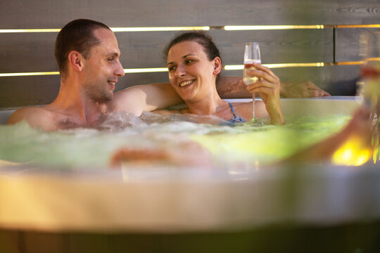 Couple Having Romantic Time In Their Garden Hot Tub Spa