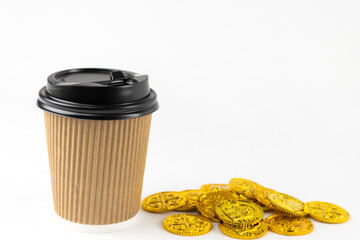 紙コップのコーヒーと、オモチャの金貨。ラテマネーのイメージ