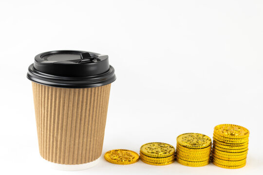 紙コップのコーヒーと、オモチャの金貨。ラテマネーのイメージ