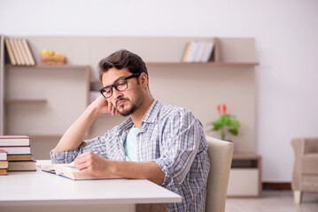 Young male student preparing for exams at home