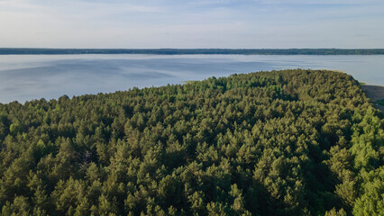 Obraz premium Aerial photo of forest on lakeside and water reservoir lake with sky reflection on water. Nature background.