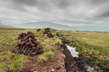Turf field in country side. Connemara, Ireland. Traditional fossil fuel for burning in a stove and...