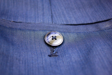 Blue mother-of-pearl button. Dark blue button on clothes design.