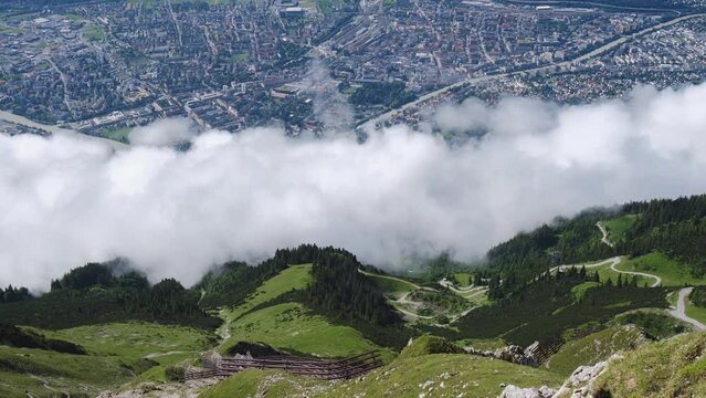 Innsbruck top view from Hafelekar, Nordkette mountains, with low clouds over the city. Timelapse, tourism, viewpoint.