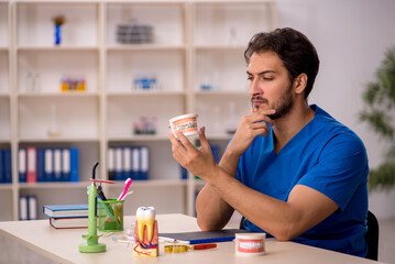 Young male dentist working in the clinic