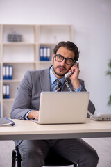 Fototapeta premium Young male employee working in the office