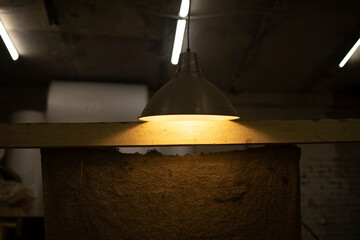 Lamp shines indoors. Interior in garage. Classic light source.