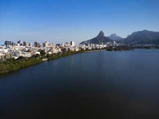 Fototapeta premium Aerial view of Rodrigo de Freitas Lagoon, south zone of Rio de Janeiro, Brazil. In the background, the beaches of Ipanema and Leblon and Morro Dois Irmãos. Sunny day. Buildings around. Drone photo