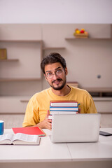 Young male student preparing for exams at home