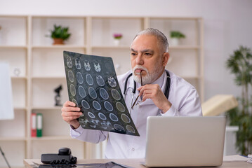 Old male doctor radiologist working in the clinic