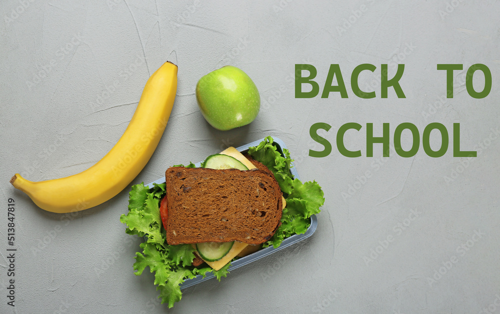 Wall mural Lunch box with tasty sandwich and fruits on light grey background, top view