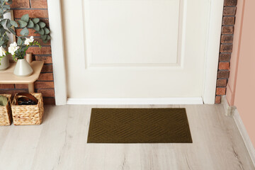 Dark olive door mat on wooden floor in hall