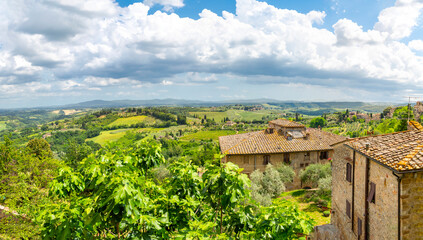 Fototapeta na wymiar Panoramic view of the Tuscan countryside from a terrace above a small farm at the medieval hill town of San Gimignano, Italy