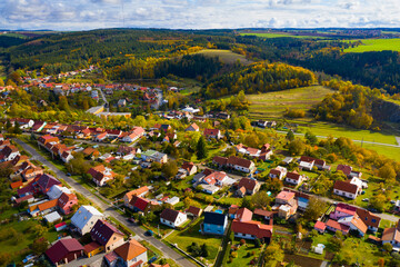 Scenic autumn landscape overlooking small Czech township of Ostrov u Macochy on sunny day, Blansko...