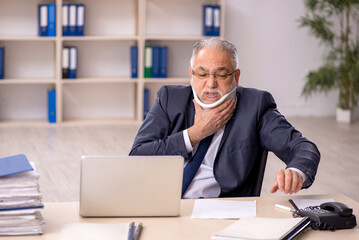 Obraz premium Old male employee after accident sitting at workplace